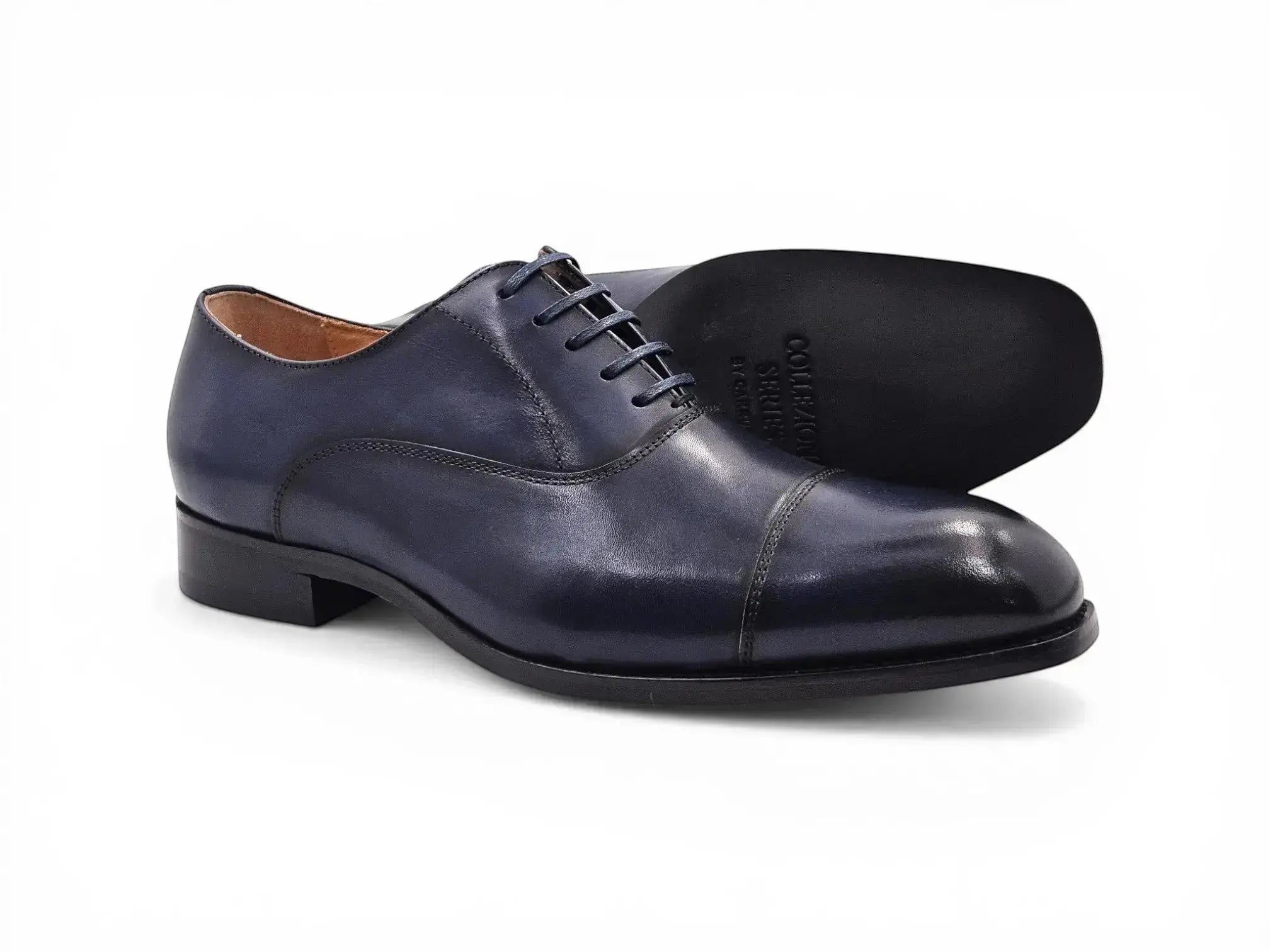 Carrucci Shoes navy blue leather cap toe oxford shoes with leather sole and closed-lace construction.
