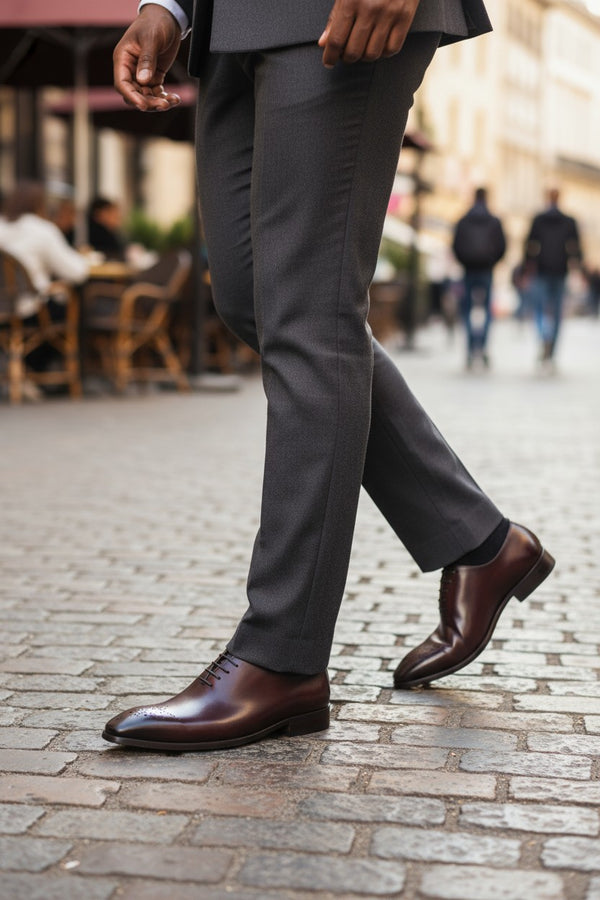 a person's legs in brown shoes